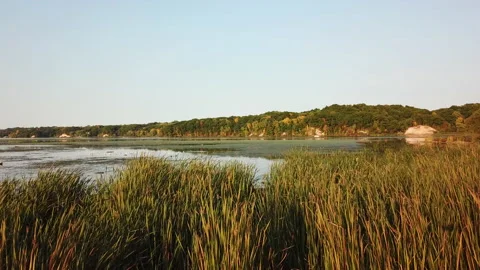 Beautiful Low Aerial over the base of calm waters at Irondequoit Bay during fall Stock Footage 141095083