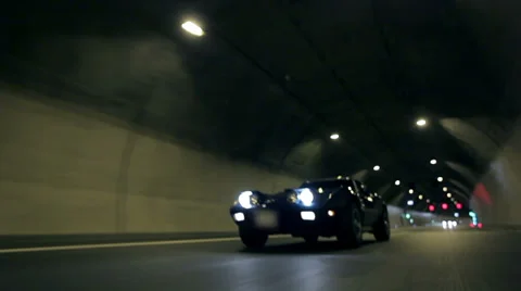 Beautiful low angle shot of Corvette C3 driving through tunnel at night Vídeos de archivo 33004114