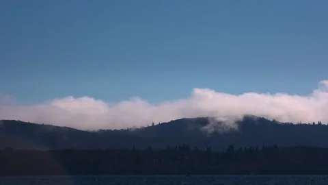 Beautiful low cloudscape over the sea and mountains, sunset time lapse shot Stock Footage 246153744