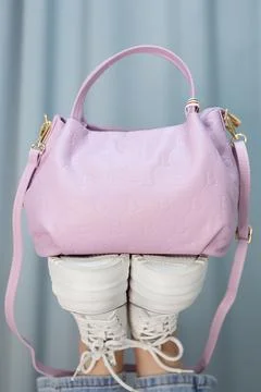 Beautiful luxurious bright violet leather handbag standing the sole of a white Stock Photos