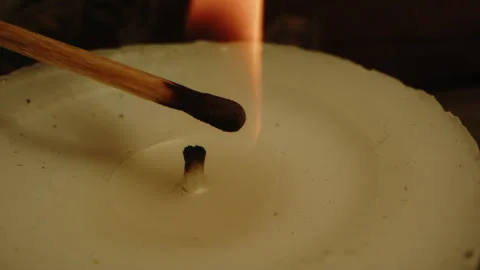 Beautiful macro of a burning match igniting the wick of a white candle Stock Footage 336003192