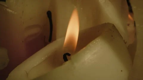 Beautiful macro of a burning white candle with a flickering orange flame Stock Footage 336004058