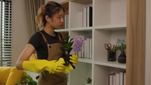 A beautiful maid is getting ready to clean the house, a maid is getting ready to Stock Footage 296670122