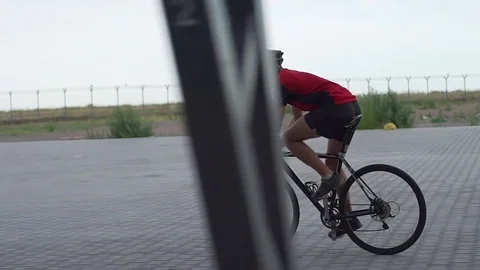 Beautiful man cycling at empty parking rapid slow motion Video stock 85000658