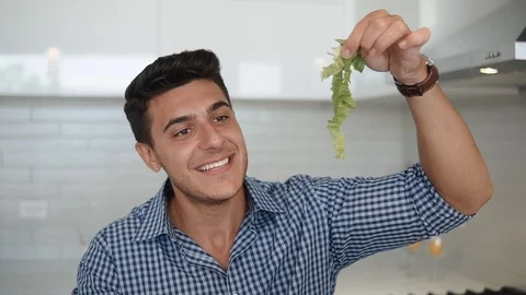 The beautiful man is salad in the kitchen Stock Footage 100576143
