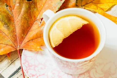 Beautiful maple leaf close-up next to a cup of hot tea Stock Photos