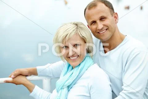A beautiful mature couple standing together, looking at camera and smiling Stock Photos