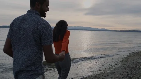 Beautiful middle eastern couple smiling and holding hands on beach Stock Footage 111976961