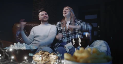 Beautiful millennials dancing on couch while watching TV musical show at home Stock Footage 147363947