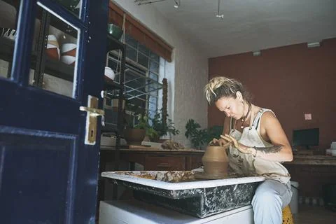 A beautiful mind makes beautiful things. a young woman working with clay in a Stock Photos