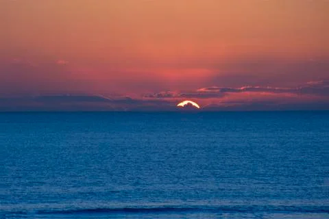 Beautiful minimal landscape seascape of stunning sunset over calm sea with de Stock Photos