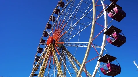 Beautiful minimalistic low angle view on huge ferris wheel spinning on clear Stock Footage 98406469