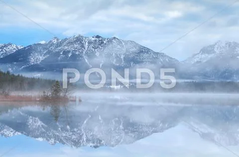 Beautiful misty morning on lake in Alps Stock Photos