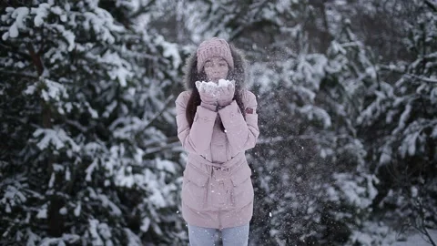 A beautiful model blows snow from her palms. Stock Footage 146659235