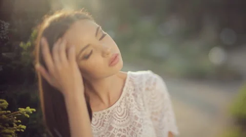 Beautiful model with bright appearance poses for a photograph in the garden Stock Footage 52850131