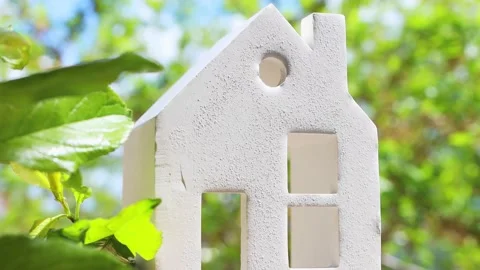 Beautiful model of a ceramic house in a natural background with plant leaves. Stock Footage 196114856