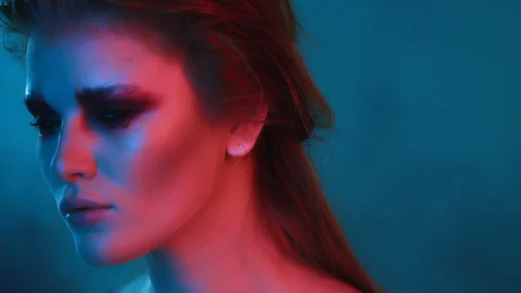 Beautiful model with dark makeup looks into camera, portrait in color lighting Stock Footage 124219377