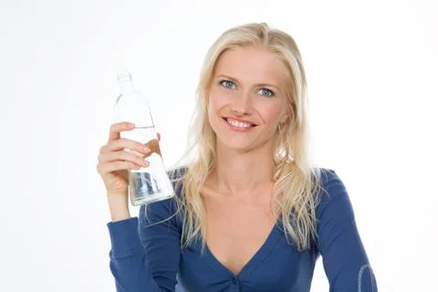 Beautiful model drinks some water from transparent glass bottle Stock Photos