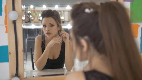 Beautiful model examines his face in the mirror. Before the photoshoot Stock Footage 71697732