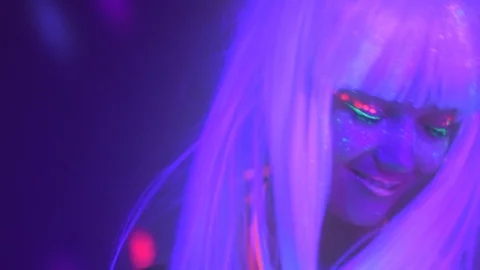 Beautiful model with fluorescent makeup on bright background. Slow motion Stock Footage 115081330