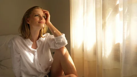 Beautiful Model with Her Thoughts Wandering by the Bed Near the Windowsill Video stock 115508406