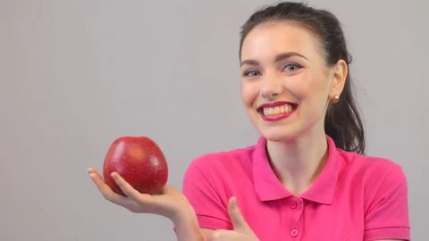Beautiful model holding red apple, thumbs up Stock Footage 73435174