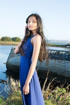 Beautiful model looking  at camera. Posing in front of old boat at the coast Stock Photos