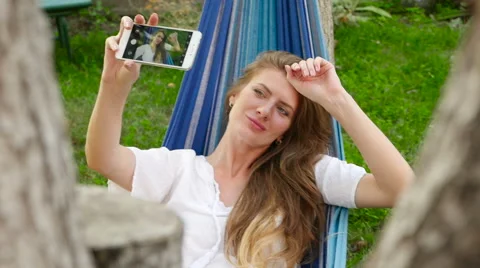Beautiful model making selfie lying in a hammock. HD Stock Footage 67667045
