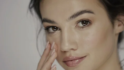 Beautiful model massaging her under eye zone and cheek Stock Footage 113288866