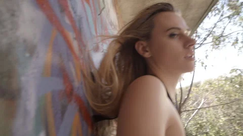 Beautiful model moves in slow motion against a graffiti wall 動画素材 45815601