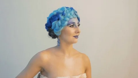 A beautiful model participates in a photo session. Makeup artists use special Stock Footage 84989861