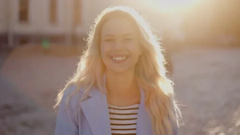 Beautiful  model smiles, posing outdoors and straightens her long hair Video stock 233960906