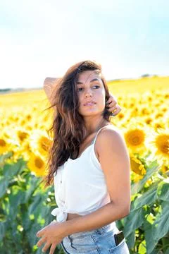 A beautiful model in a sunflower field. Perfect shot for leisure, fashion, su Stock Photos
