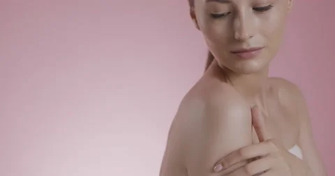 Beautiful model touching bare shoulder over pink background Stock Footage 158754751