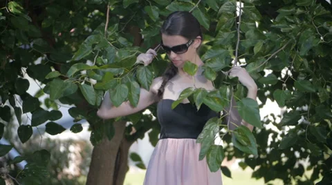 Beautiful model walks through tree branches Stock Footage 34514207