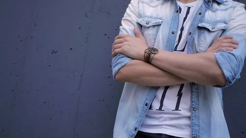 Beautiful model young guy poses by the wall Stock Footage 72833966