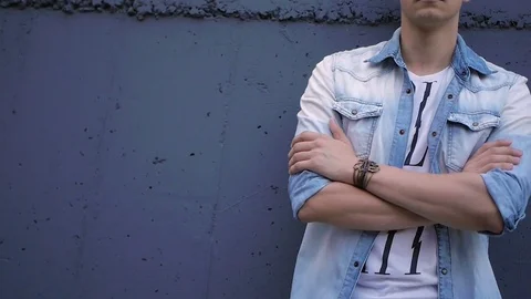Beautiful model young guy poses by the wall Stock Footage 72834031