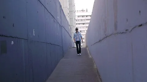 Beautiful model young guy poses by the wall Stock Footage 72834545