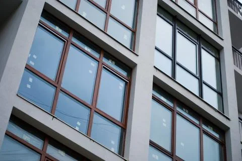 Beautiful modern apartment house. Rectangular windows reflect cold blue daylight Stock Photos