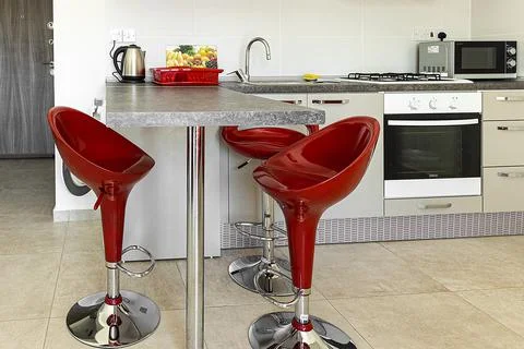 Beautiful modern kitchen interior with a breakfast bar in red and white color Stock Photos