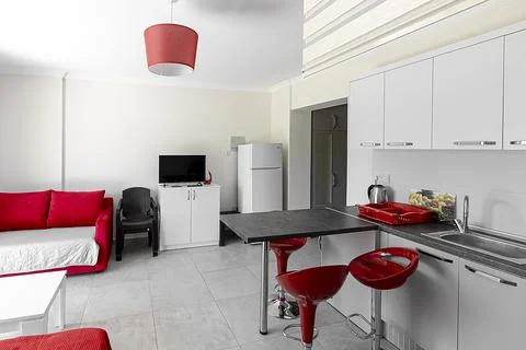 Beautiful modern kitchen interior with a breakfast bar in red and white color Stock Photos