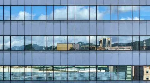 Beautiful modern tall tower with clouds in financial district. Windows skylin Ilustración de archivo