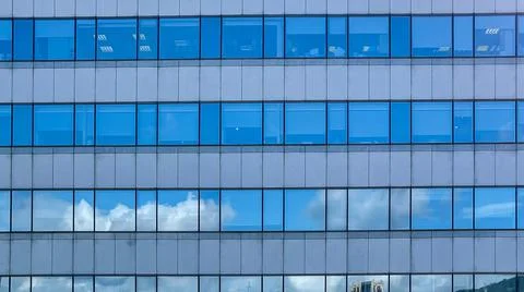 Beautiful modern tall tower with clouds in financial district. Windows skylin Ilustración de archivo