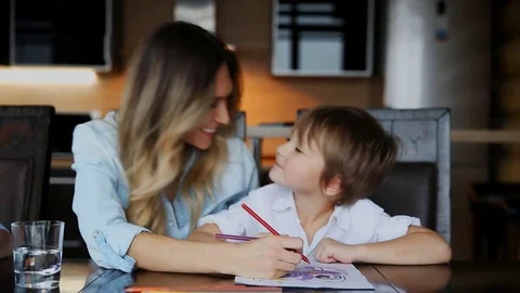 Beautiful mom helps her son to paint wit... | Stock Video | Pond5