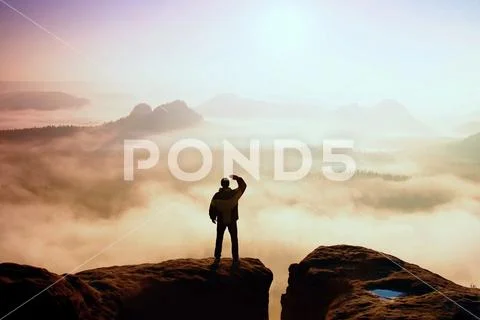 Beautiful moment the miracle of nature. Man stands on the peak of sandstone.. Stock Photos