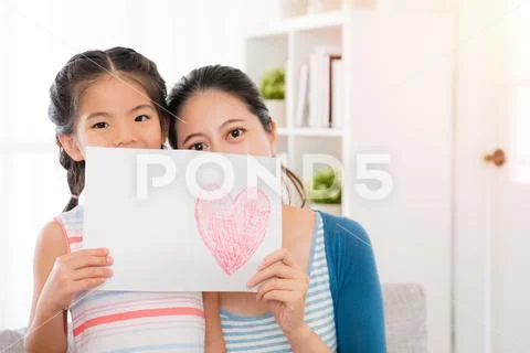 Beautiful mother and youth daughter holding a card Stock Photos