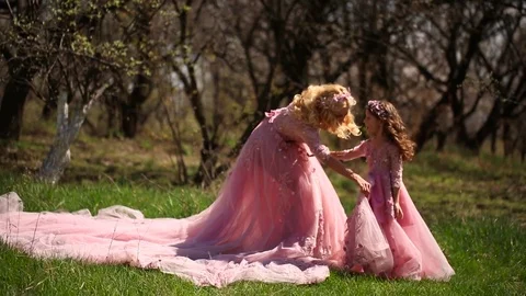 Beautiful Mother with a Young Daughter in pink Dresses Stock Footage