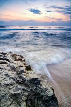 Beautiful motion, soft wave hitting rock on the sandy beach over magnificent  Stock Photos