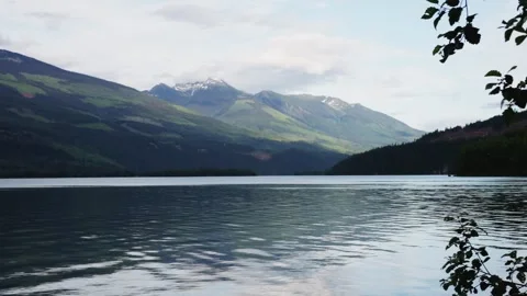 A beautiful mountain lake with a tree branch in the foreground Stock Footage 252559629