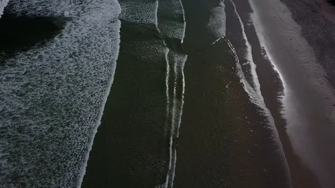 Beautiful Mountain Range Behind Waves Crashing On Beach [Drone Footage] Stock Footage 91040509